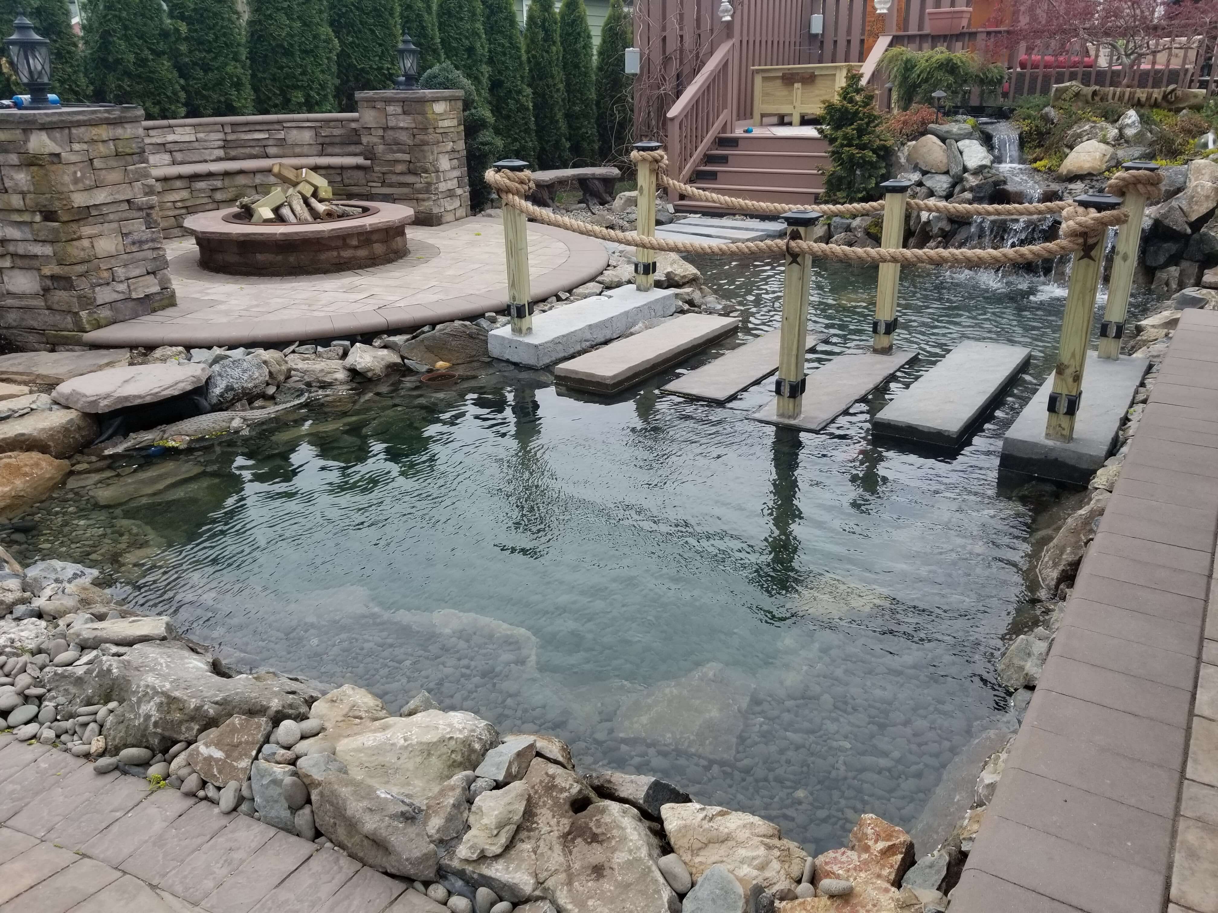 Luxury backyard pond Long Island custom water feature relaxing outdoor environment natural stone waterfall